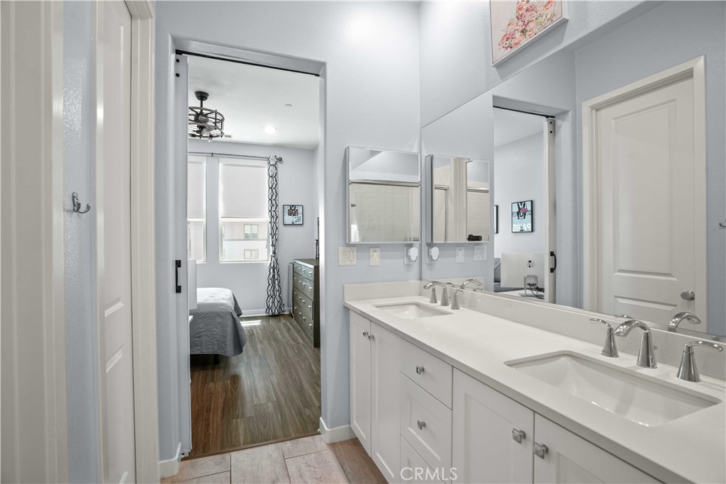 26973 West Prospector Road, Unit 302 Valencia, CA 91381 - Photo 14 of 22 a en suite bathroom with a granite countertop sink mirror and double
