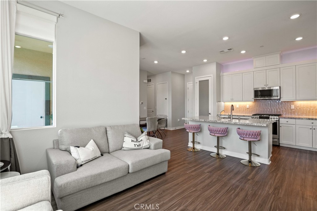 26973 West Prospector Road, Unit 302 Valencia, CA 91381 - Photo 6 of 22 a living room with kitchen island furniture and a wooden floor
