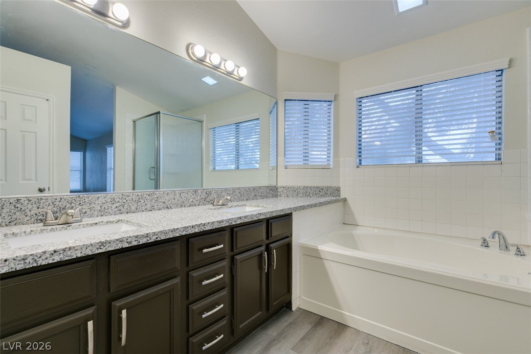 1738 Toltec Circle Henderson, NV 89014 - Photo 29 of 46 Double vanity with stone counters and a separate soaking tub create a functional, refreshing bathroom space.