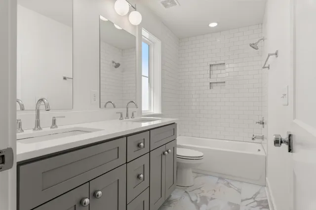 a bathroom with a granite countertop sink a toilet and shower