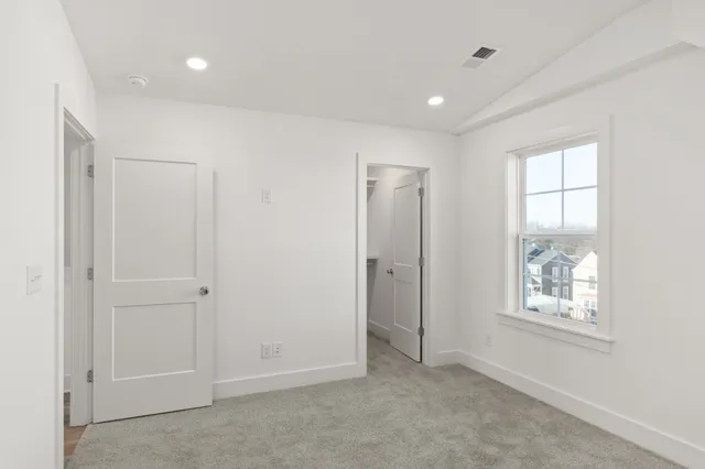 a view of an empty room with windows and closet