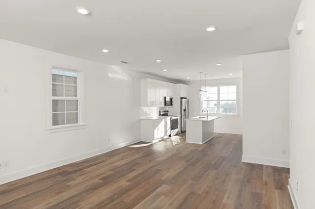 a view of a kitchen with wooden floor and a window