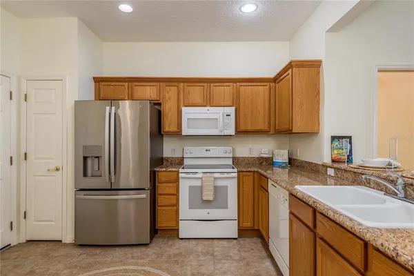 a kitchen with granite countertop a sink stainless steel appliances and cabinets