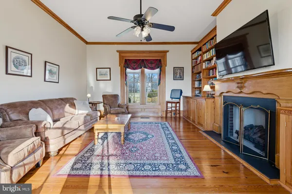 a living room with fireplace furniture and a large window