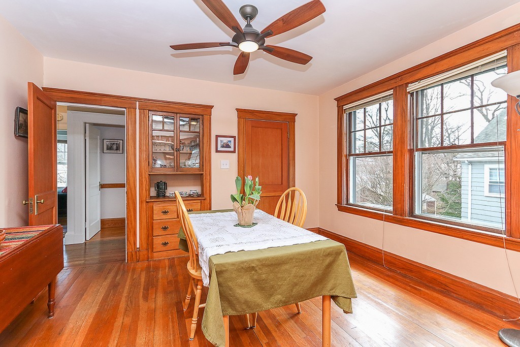 112-114 Adena Road, Unit 112 Newton, MA 02465 - Photo 5 of 16 a dining room with wooden floor a chandelier fan a wooden table and chairs