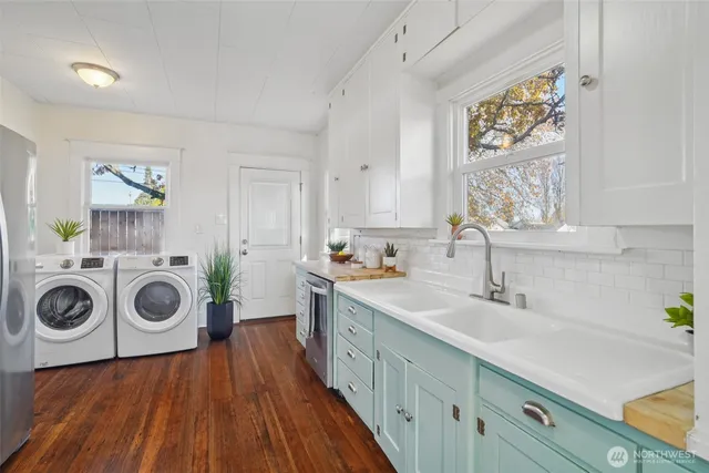 a kitchen with a stove a sink and wooden floor