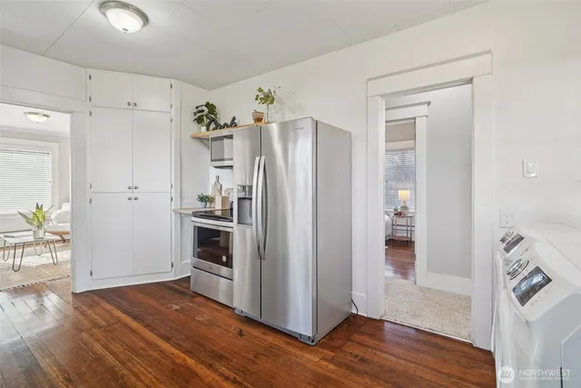 a kitchen with stainless steel appliances a refrigerator and wooden floor