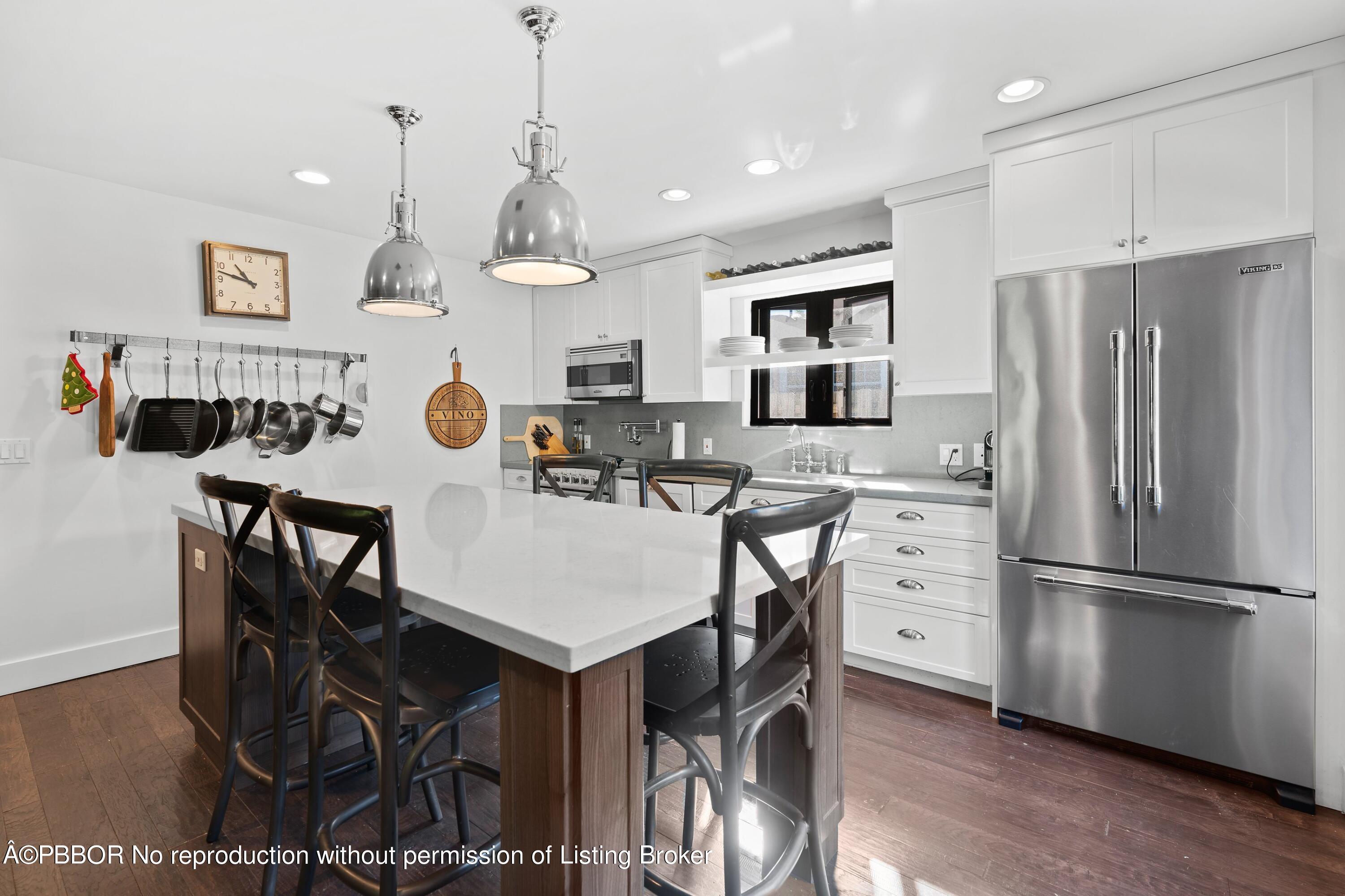 3210 Vincent Road West Palm Beach, FL 33405 - Photo 8 of 20 a kitchen with stainless steel appliances kitchen island granite countertop a refrigerator a stove a microwave oven a dining table and chairs with wooden floor