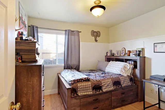 a bedroom with a bed and wooden floor