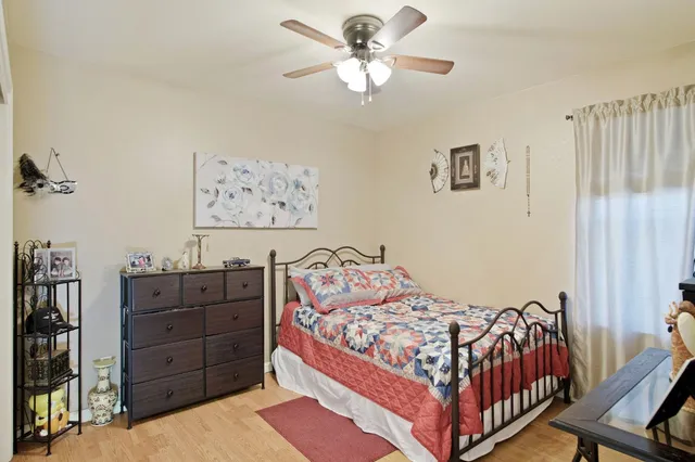 a bed sitting in a bedroom next to a window and a chandelier