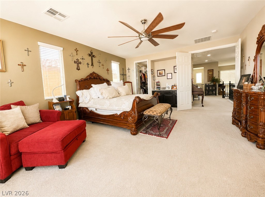 9724 University Ridge Avenue Las Vegas, NV 89149 - Photo 51 of 61 Elegant primary bedroom offers plush carpeting, a detailed bed frame, and an open layout to an adjacent area.