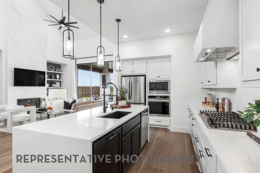 4415 Azalea Trail Oak Point, TX 75068 - Photo 6 of 38 a kitchen with stainless steel appliances a sink a stove top oven a counter space and cabinets
