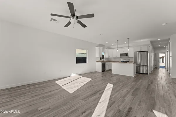 a view of kitchen with granite countertop cabinets and refrigerator