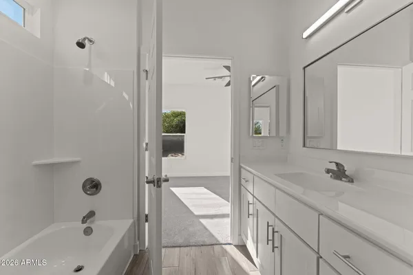 a bathroom with a tub sink and mirror