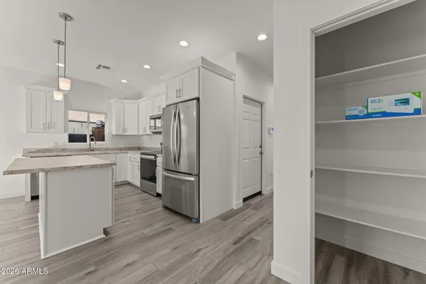 a kitchen with white cabinets and stainless steel appliances