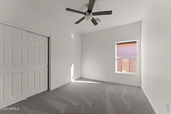 a view of a livingroom with a ceiling fan and window