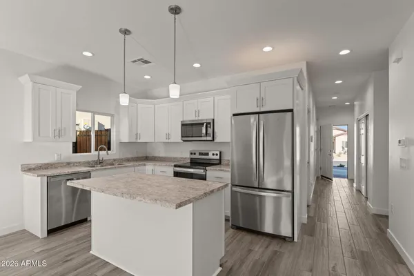 a kitchen with stainless steel appliances granite countertop a refrigerator a sink and a stove