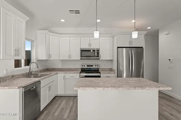 a kitchen with kitchen island a sink stainless steel appliances and cabinets