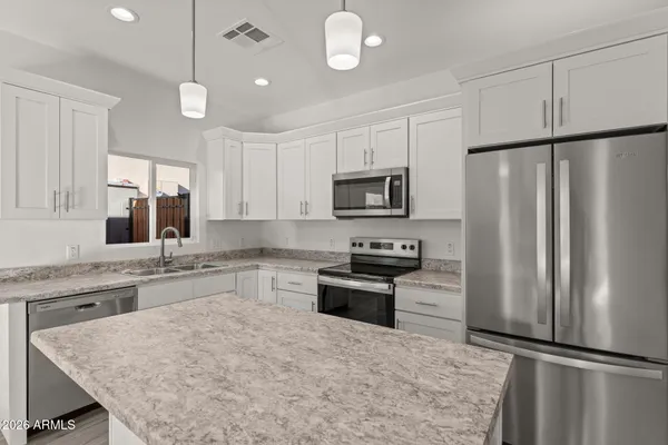 a kitchen with granite countertop a refrigerator stove top oven and sink