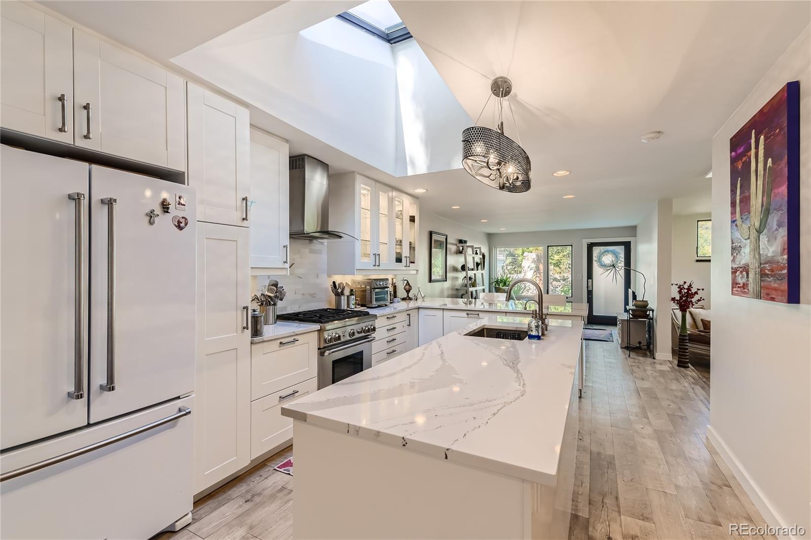 161 3rd Avenue Niwot, CO 80544 - Photo 11 of 41 a kitchen with stainless steel appliances granite countertop a refrigerator a sink dishwasher a stove and white cabinets with wooden floor