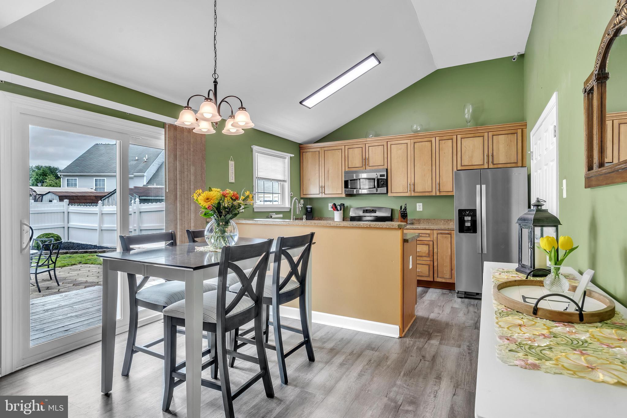 5 Patricia Circle Bear, DE 19701 - Photo 6 of 23 a kitchen with stainless steel appliances granite countertop wooden floor a dining table and chairs