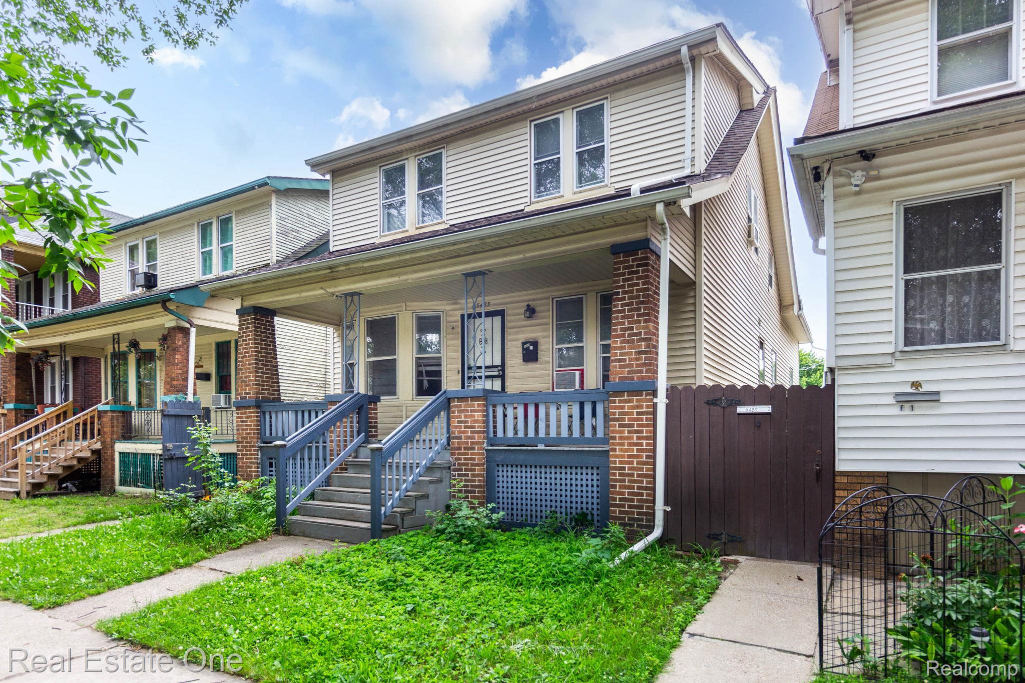 5485 Springwells Street Detroit, MI 48210 - Photo 2 of 47 Two-story residence featuring siding exterior, a covered front porch with a wood railing, and brick column bases
