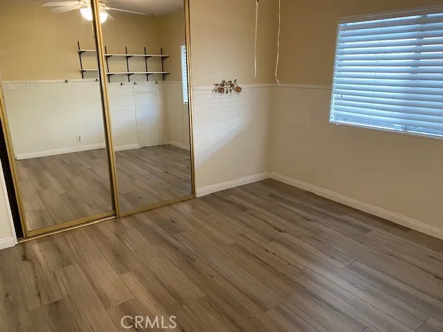 an empty room with wooden floor and a shower