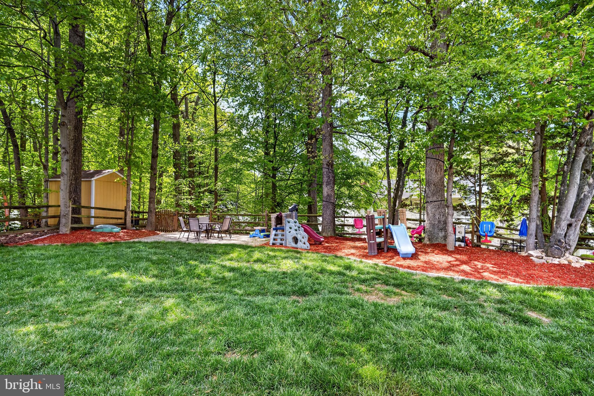 8373 Magic Leaf Road Springfield, VA 22153 - Photo 12 of 69 a view of a park with large trees and a wooden fence