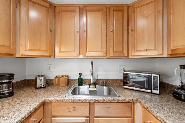 a kitchen with stainless steel appliances granite countertop a refrigerator a sink a stove a microwave oven with white cabinets