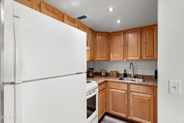 a kitchen with stainless steel appliances granite countertop a refrigerator and a stove top oven