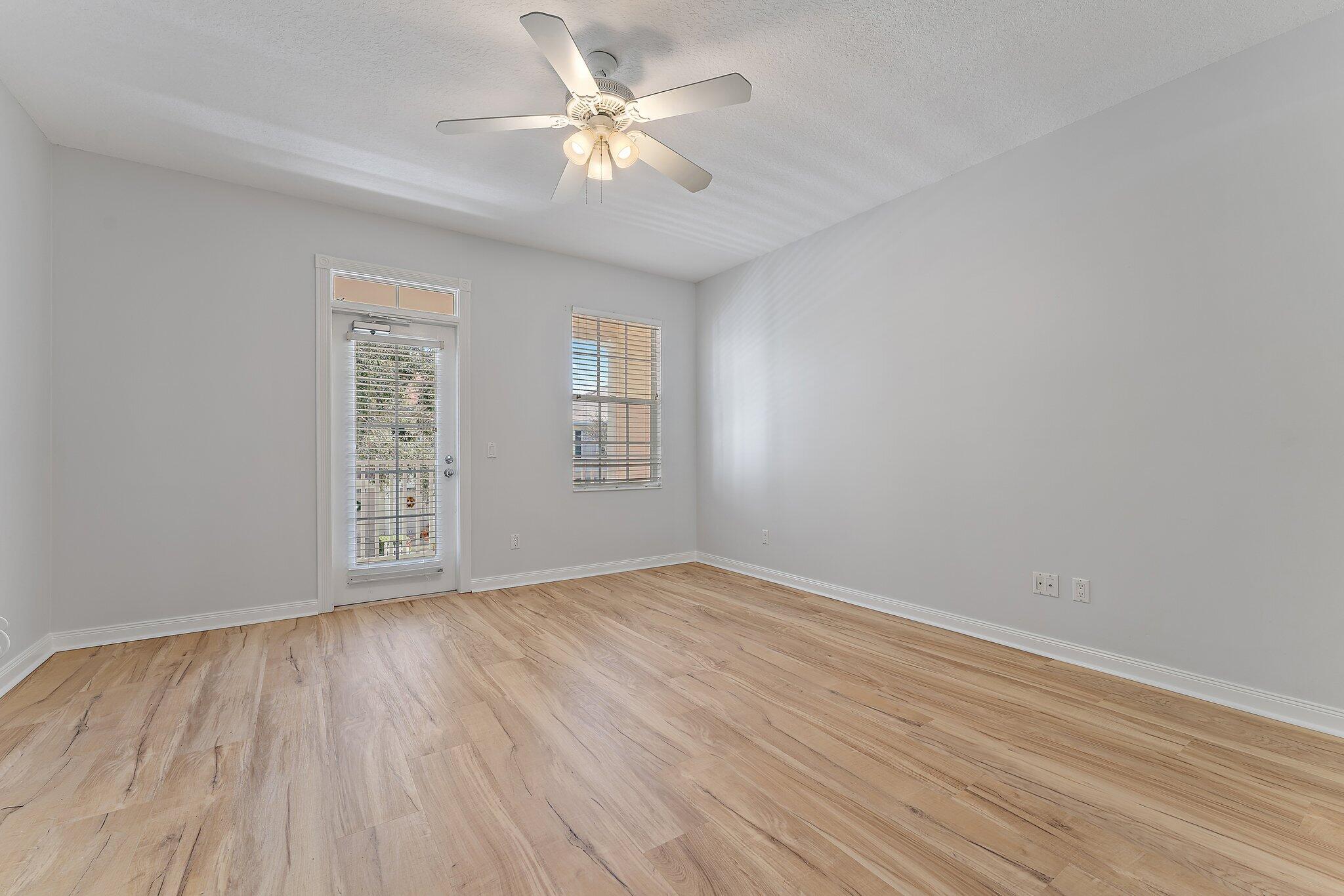 148 Middlebury Drive Jupiter, FL 33458 - Photo 18 of 32 wooden floor in an empty room with a window