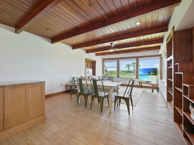 a living room with furniture a flat screen tv and large window