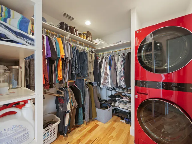 a kitchen with stainless steel appliances a stove a sink cabinets and a wooden floor