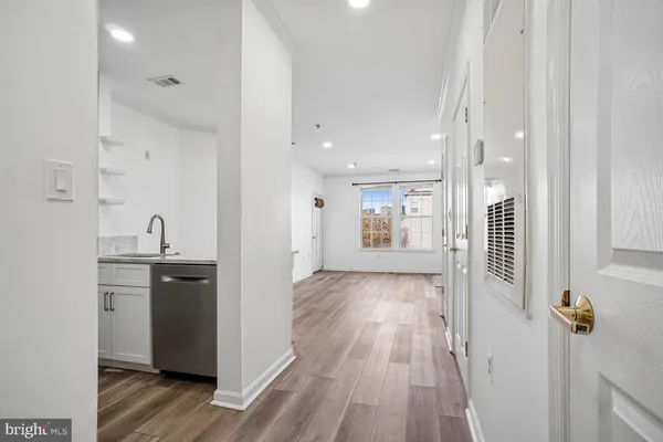 a kitchen with granite countertop white cabinets and stainless steel appliances