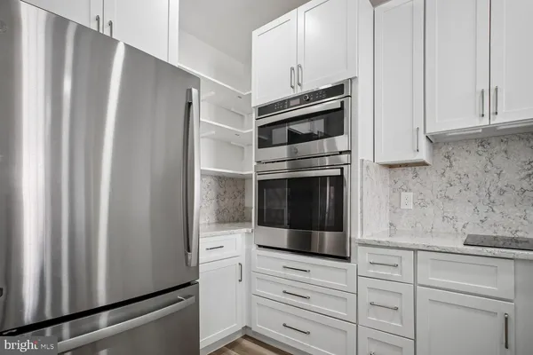 a kitchen with granite countertop white cabinets and stainless steel appliances