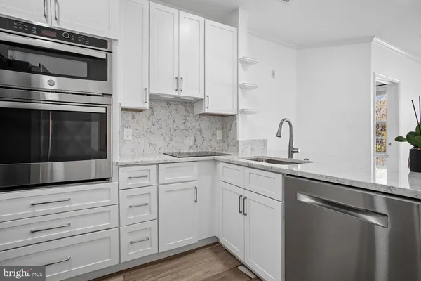 a kitchen with kitchen island wooden floors and refrigerator