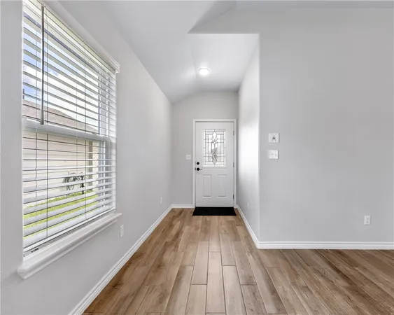 a view of a room with wooden floor and window