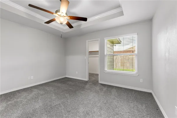 an empty room with a window and a fan