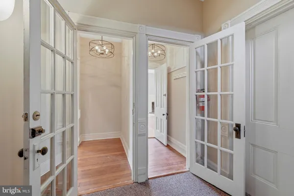 a view of a hallway with wooden floor and entryway