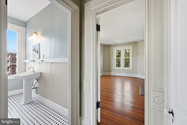 a view of a room with wooden floor windows and a bathroom
