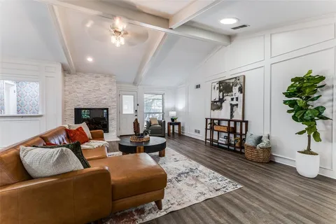 a living room with furniture fireplace and wooden floor