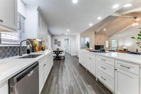 a large kitchen with stainless steel appliances lots of counter space and a sink