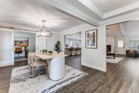 a view of a dining room and livingroom with furniture wooden floor a chandelier