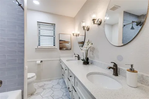 a bathroom with a sink a toilet and a mirror
