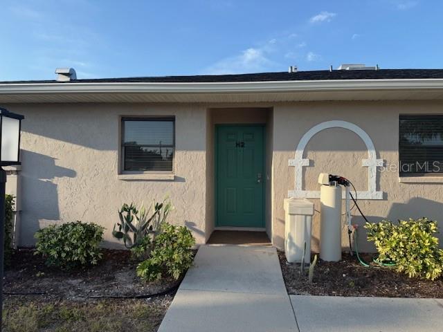 24540 Harbor View Road, Unit H2 Punta Gorda, FL 33980 - Photo 3 of 21 a front view of a house with lots of potted plants