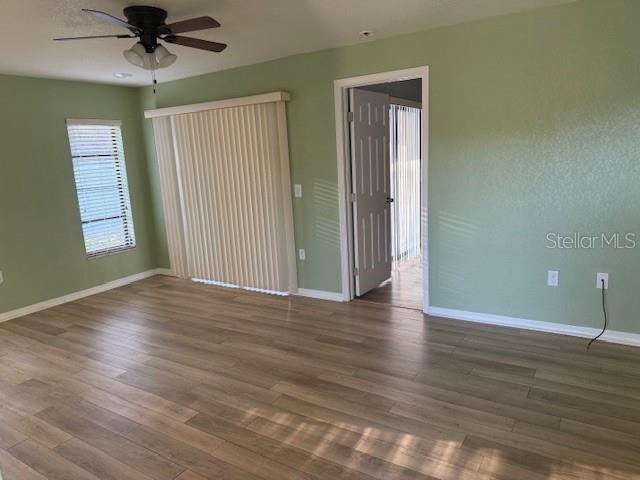 24540 Harbor View Road, Unit H2 Punta Gorda, FL 33980 - Photo 5 of 21 an empty room with wooden floor fan and windows