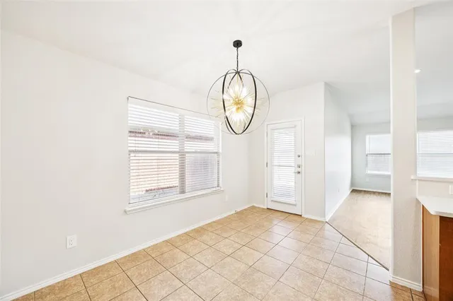 a view of an empty room with wooden floor and window