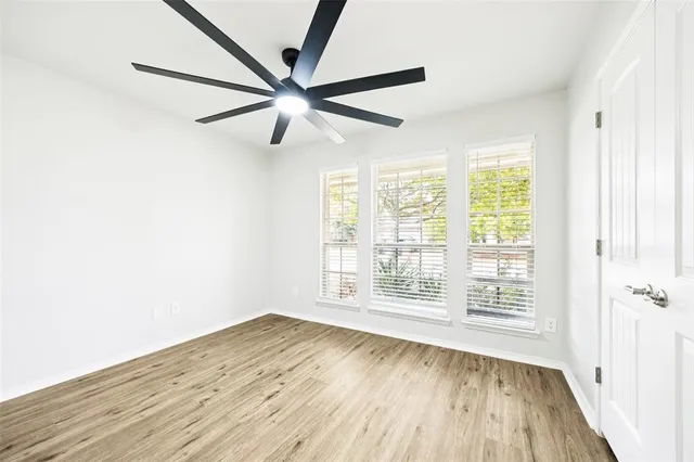 an empty room with a window and a fan
