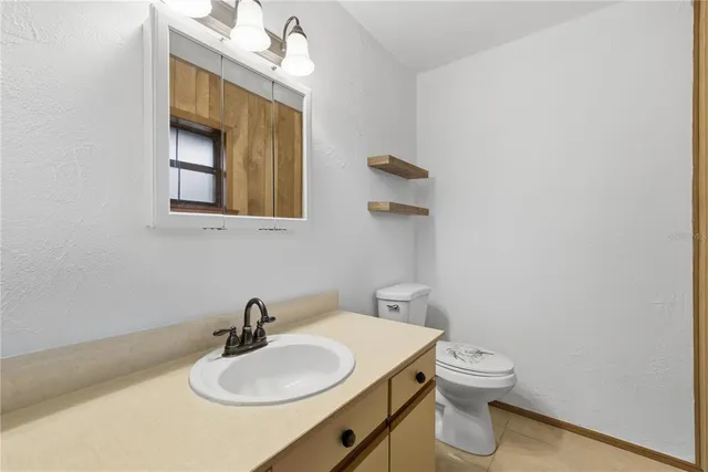 a bathroom with a toilet a sink and mirror
