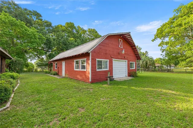 a view of a house with backyard and trees